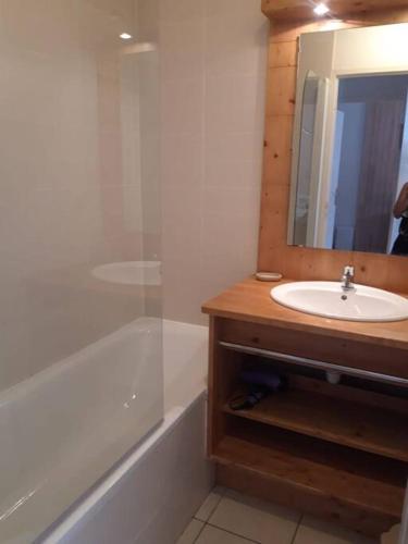 une salle de bain avec un lavabo, un miroir et une baignoire dans l'établissement T2 Les orres 1800 pied des pistes avec piscine, aux Orres