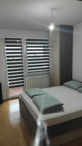 a bedroom with a bed with two green towels on it at Maki & Dare Apartment Ilidza in Sarajevo