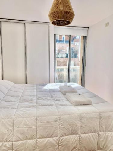 - une chambre avec un grand lit blanc et une grande fenêtre dans l'établissement Ayres de Córdoba 2, Asador, Terraza, Balcón, Excelente Ubicación, à Córdoba