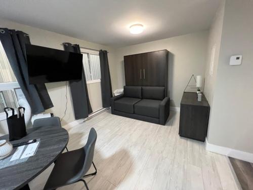 a living room with a television and a couch at Le Centre-Ville in Rouyn
