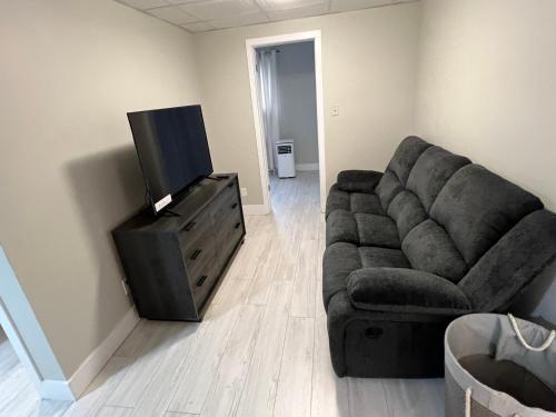 a living room with a couch and a flat screen tv at Le Centre-Ville in Rouyn
