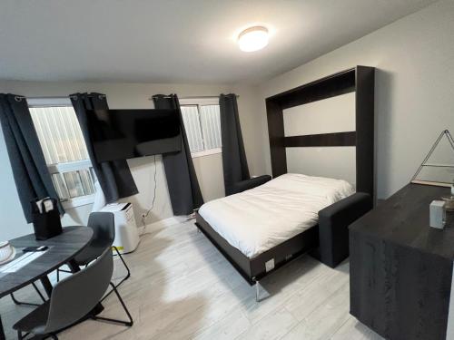 a bedroom with a bed and a desk and a desk at Le Centre-Ville in Rouyn