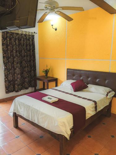 a bedroom with a bed and a ceiling fan at Hotel Hacienda la Alborada in Tuxtla Gutiérrez