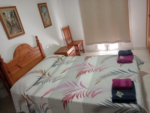 1 dormitorio con 1 cama con 2 toallas en La redonda en San Roque