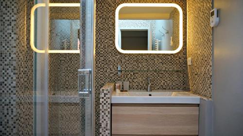 ein Bad mit einem Waschbecken und einem Spiegel in der Unterkunft Little Suite - Simone in Lille