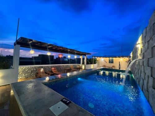 uma piscina no quintal de uma casa à noite em Hotel Ko'ox Wenne em Tulum