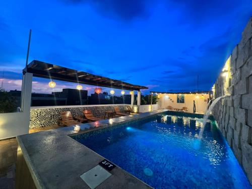 a swimming pool in the backyard of a house at night at Hotel Ko'ox Wenne in Tulum