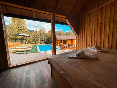 een kamer met een bed en een groot raam met een zwembad bij Hellena in Sarajevo