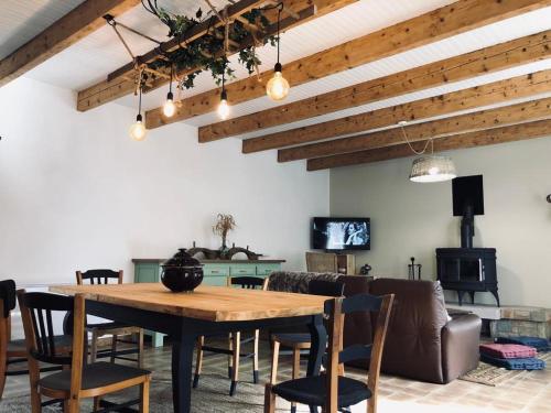 comedor con mesa de madera y sillas en Longère bretonne chaleureuse près de la mer en Yvias