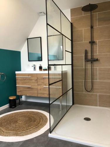 une salle de bain avec une douche en verre et un lavabo dans l'établissement Longère bretonne chaleureuse près de la mer, à Yvias
