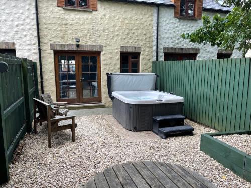 a backyard with a hot tub and a chair and a fence at Cottage With Hot Tub in Pembrokeshire in Haverfordwest