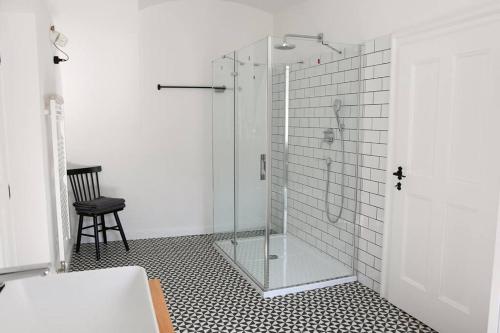 uma cabina de duche em vidro numa casa de banho com uma cadeira em Beautiful 2bed apartment in the centre of Varazdin em Varaždin