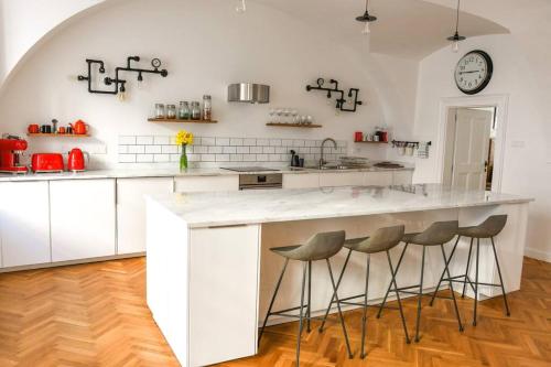 uma cozinha com um grande balcão branco com bancos em Beautiful 2bed apartment in the centre of Varazdin em Varaždin