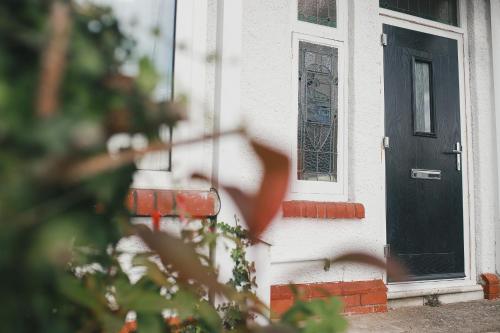 una puerta negra en una casa blanca con una ventana en 39 Court Rd en Bristol