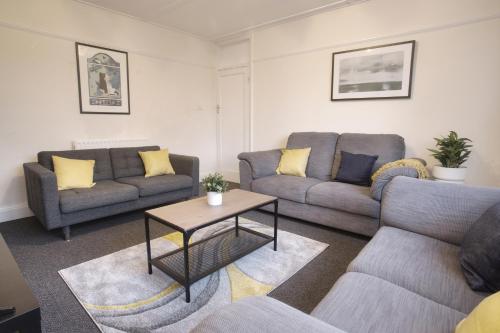 a living room with two couches and a table at Druids Hill in Bristol
