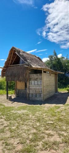 an old wooden building with a grass roof at biohotel tatacoa Qji in Villavieja