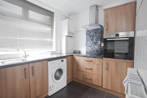 a kitchen with a washing machine and a washer at 4 Elmhurst Avenue in Bristol