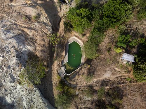 an aerial view of a green cave in a rock formation at biohotel tatacoa Qji in Villavieja