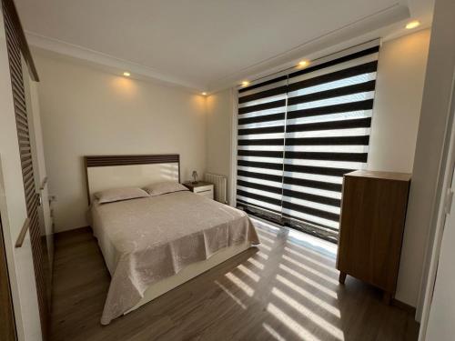 um quarto com uma cama e uma grande janela em Beachside Villa em Silivri