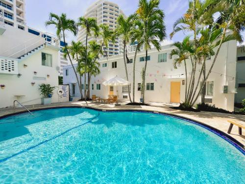 a large swimming pool in front of a building with palm trees at North Beach Hotel in Fort Lauderdale