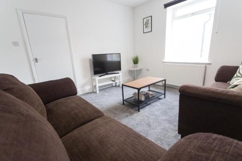 a living room with a couch and a tv at Three Bed - Suitable for Contractors- Large Groups in Bristol