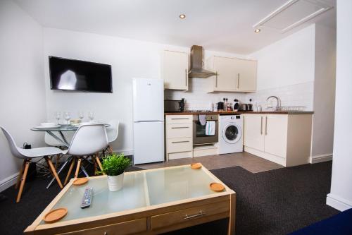 a living room with a table and a kitchen at 56b Mina rd in Bristol