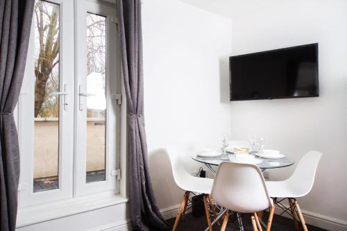 a dining room with a table and chairs and a window at 56b Mina rd in Bristol