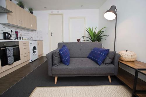 ein Wohnzimmer mit einem Sofa und blauen Kissen in der Unterkunft 56a Mina Rd in Bristol