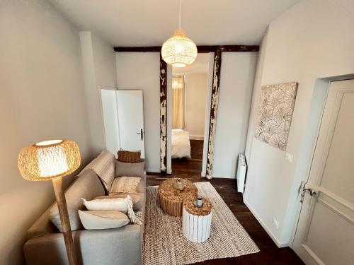 een woonkamer met een bank en een lamp bij Les Suites de la Tour d'Embas in Vitré