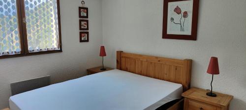 1 dormitorio con cama blanca y ventana en Bel appartement avec vue, en Barèges