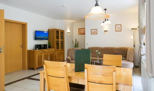 a living room with a table and chairs and a couch at Ferienanlage Zum Wildbach Schierke in Schierke
