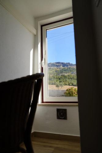 a window in a room with a chair looking out at Casa da Portagem by Portus Alacer in Marvão