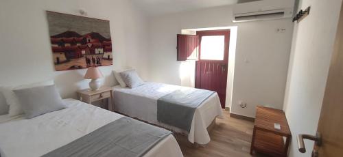 a hotel room with two beds and a window at Casa da Portagem by Portus Alacer in Marvão