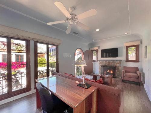 a living room with a dining table and a fireplace at Casa Del Mar Inn in Santa Barbara
