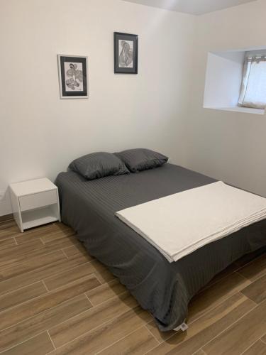 1 dormitorio con 1 cama grande y suelo de madera en Gîte chaleureux avec poêle à granulés, en Tanis