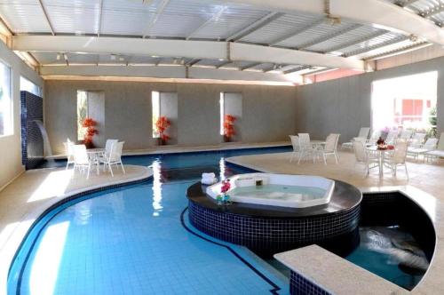 a large swimming pool with a hot tub in a building at Hotel Premium Campinas in Campinas