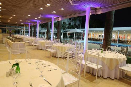 a banquet hall with white tables and chairs and a pool at Hotel Premium Campinas in Campinas