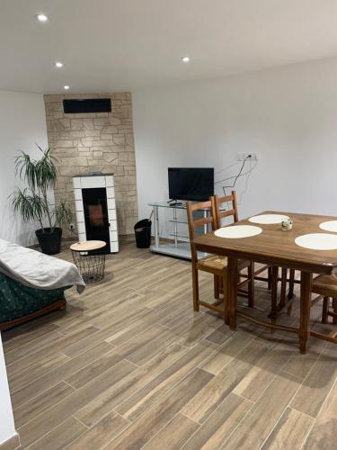 un salon avec une table et une cheminée dans l'établissement Gîte chaleureux avec poêle à granulés, à Tanis