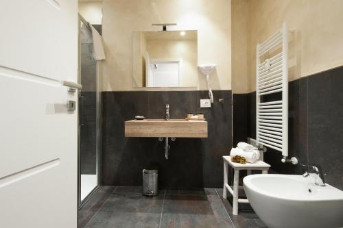 a bathroom with a sink and a mirror at Brichett Deluxe Rooms in Alba