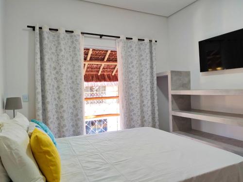 a bedroom with a large bed and a window at Sirena Village in São Miguel do Gostoso