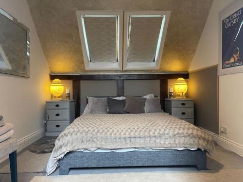 Winforton的住宿－Stylish 2-bed cottage with secure parking，一间卧室配有一张带2个床头柜和2盏灯的床。