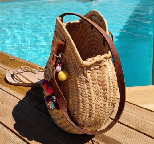 a purse sitting on a deck next to a pool at Apartamento para pareja, Finca Contrabando. Sanlucar del Guadiana in Sanlúcar de Guadiana