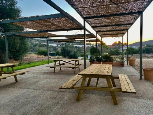 a group of picnic tables under a pavilion at Apartamento para pareja, Finca Contrabando. Sanlucar del Guadiana in Sanlúcar de Guadiana