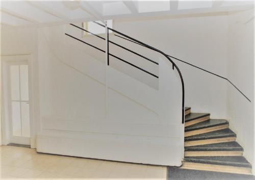 a staircase in a white building with a metal railing at Apartmá v srdci Poděbrad in Poděbrady