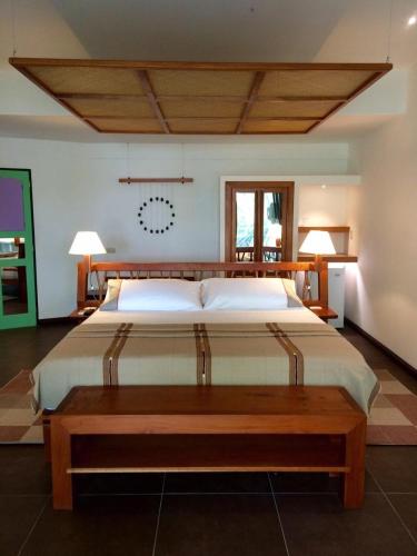 a bedroom with a large bed and a wooden table at Hotel Maya Internacional in Flores