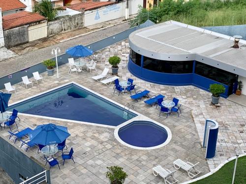 a swimming pool with blue chairs and umbrellas at Terrazzo PontaNegra flat Flat Vista Mar Apto 201 in Natal