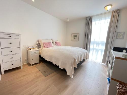 a bedroom with a bed and a dresser and a window at Naustavör 30 in Reykjavík