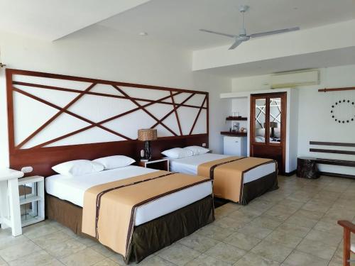 two beds in a hotel room with at Hotel Maya Internacional in Flores