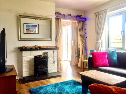 a living room with a couch and a fireplace at Sea Bean 2 Bedroom House Manorbier Tenby Pet Friendly in Manorbier