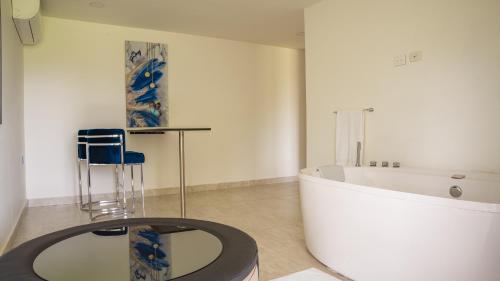 佩雷拉的住宿－Hotel Palo Grande CF Pereira，带浴缸、桌子和椅子的浴室